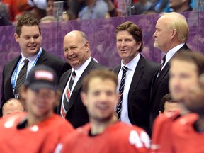 Claude Julien (second from left) and head coach Mike Babcock look on during the medal ceremony after Team Canada defeated Sweden 3-0 during the Men's Ice Hockey Gold Medal match on Day 16 of the 2014 Sochi Winter Olympics at Bolshoy Ice Dome on February 23, 2014 in Sochi, Russia.