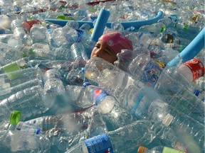TOPSHOT - A child swims in a pool filled with plastic bottles during an awareness campaign to mark the World Oceans Day in Bangkok on June 8, 2019.
