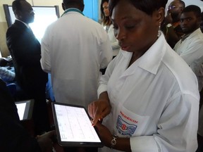 An Ivorian doctor uses a tablet computer in Bouake hospital's trailblazer telemedicine departement for heart diseases, in Bouake on June 20, 2019. - The lives of several thousand patients have changed with the setting up of a pioneering telemedicine service at the University Hospital Center of Bouaké, spreading to all of northern Ivory Coast. Patrick Déry says that in Canada, provincial governments have set out all sorts of conditions that restrict access to telemedicine.