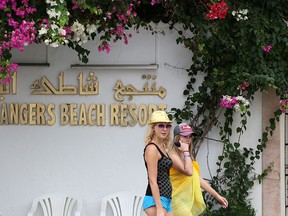 British tourists walk outside the Orange Beach hotel in in Tunisia's coastal town of Hammamet on Monday, Sept. 23 2019.