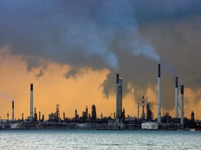 FILE PHOTO: Smoke billows from the towers of an oil refinery off the coast of Singapore March 14, 2008. REUTERS/Vivek Prakash/ Files