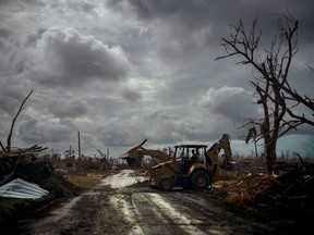Mos Antenor, 42, drives a bulldozer while clearing the road after Hurricane Dorian Mclean's Town, Grand Bahama, Bahamas, on Friday, Sept. 13, 2019.