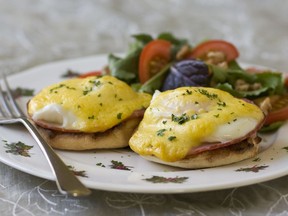 Eggs benedict with sliced tomatoes.