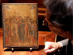 Art expert Eric Turquin inspects the painting "Christ Mocked", a long-lost masterpiece by Florentine Renaissance artist Cimabue in the late 13th century, which was found months ago hanging in an elderly woman's kitchen in the town of Compiegne, displayed in Paris, France, September 24, 2019.    REUTERS/Charles Platiau