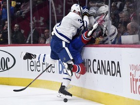 Toronto Maple Leafs defenceman Justin Holl (3) checks Montreal Canadiens forward Jesperi Kotkaniemi (15) into the boards during the first period at the Bell Centre on Monday, Sept. 23, 2019.