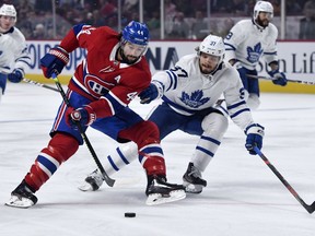 Canadiens forward Nate Thompson, left, protects the puck from Leafs defenceman Timothy Liljegren during pre-season action at the Bell Centre.