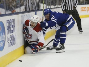 Leafs defenseman Rasmus Sandin  takes Canadiens forward Nick Suzuki into the boards during the first period Wednesday night at Scotiabank Arena.