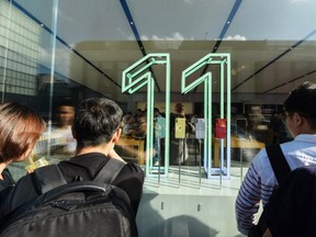 Customers look at the latest iPhone models displayed inside an Apple store in Hangzhou in China's eastern Zhejiang province on September 20, 2019.