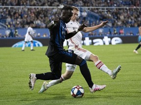 Impact defender Bacary Sagna, left, and Toronto FC's Jacob Shaffelburg battle for the ball during second half of the first leg of the Canadian Championship action at Saputo Stadium on Wednesday night.