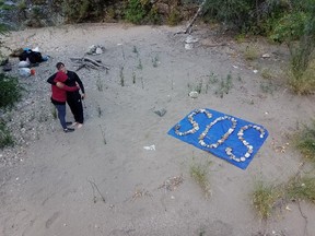 Krystal Ramirez and Hunter Whitson embrace after creating an SOS message out of rocks.