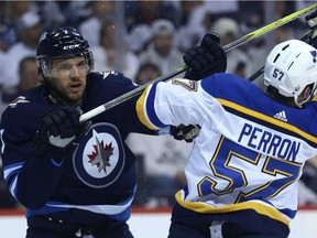 Former Winnipeg Jets defenceman Ben Chiarot, left, battles with St. Louis Blues forward David Perron during Game 5 of the first round of the NHL playoffs in Winnipeg on April 18, 2019.