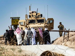 Syrian Kurds take part in a demonstration against Turkish threats at a U.S.-led international coalition base on the outskirts of Ras al-Ain town in Syria's Hasakeh province near the Turkish border on October 6, 2019.