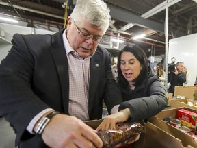 Montreal Mayor Valérie Plante looks at the ingredients of a bag of cookies with Moisson Montreal executive director Richard Daneau during a visit to the food bank's warehouse in January 2019.