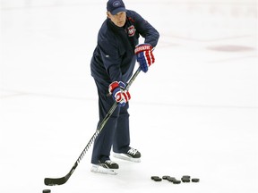 Canadiens coach Claude Julien passes pucks during training-camp practice at the Bell Sports Complex in Brossard on Sept. 14, 2018.