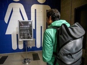 A commuter reads sign outside washrooms at the Lucien L'Allier train station in Montreal on Thursday, Oct. 3, 2019.