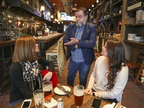 Roger Costa, partner and general manager at Wienstein and Gavino's in downtown Montreal, speaks to customers Colleen Wolfe, left, and Taryn Eilers on Saturday Oct. 5, 2019. "As someone who operates a business and who has obligations to employees, suppliers and even the government itself, I have to keep my business going," Costa says. "And the instinct is to accommodate the guest."