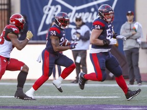 Montreal Alouettes offensive-lineman Chris Schleuger is the lead blocker for running-back Jeremiah Johnson against the Calgary Stampeders in Montreal on Oct. 5, 2019.