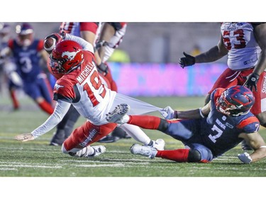 Alouettes defensive end John Bowman hauls down Calgary Stampeders quarterback Bo Levi Mitchell by his shirt for a sack in Montreal on Saturday, Oct. 5, 2019.