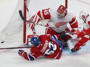 Canadiens forward Artturi Lehkonen slides into Detroit Red Wings goaltender Jonathan Bernier with Filip Hronek coming in on the play during third period of NHL game at the Bell Centre in Montreal on Oct. 10, 2019.