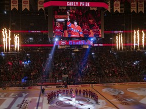 Montreal Canadiens goaltender Carey Price raises torch during the home ice opening ceremonies, prior to Montreal Canadiens and Detroit Red Wings NHL game in Montreal on Oct. 10, 2019.