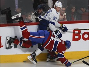 Canadiens centre Nate Thompson is sent to the ice by Lightning centre Steven Stamkos during play Tuesday night at the Bell Centre.