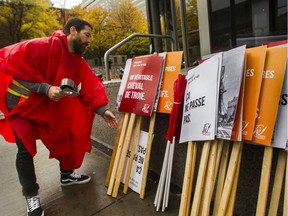 Teacher and union councillor Martin Bibeau packs up signs (with messages such as 'Bill 40-One of the worst attacks against teachers', 'Bill 40 Will Not Pass' and 'Bill 40-A Real Trojan Horse') after a protest against Bill 40 that teachers with the Fédération Autonome de l'enseignment held outside the Château Champlain in Montreal on Thursday, Oct. 24, 2019. Quebec Education Minister François Roberge was attending a luncheon there.
