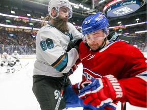 Canadiens forward Tomas Tatar gets pushed into the boards by San Jose Sharks defenceman Brent Burns during third period of NHL game at the Bell Centre in Montreal on Oct. 24, 2019.