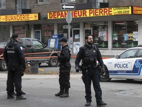 Montreal police stand outside one of the scenes of Thursday's shootings, at Matte Ave. and Pierre St. in Montreal North.
