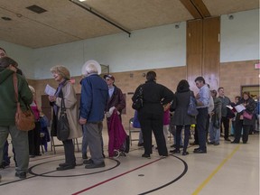 Voters line up at St. Monica Elementary School during the advance polls for school board election in Montreal, on Sunday, October 26, 2014. Bill 40 would abolish school boards but, in the English system, still provide for the election of board members of the service centres that are to replace them.