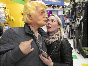 Maksym Tsypeniuk seems to enjoy his new look after he puts on President Donald Trump mask, to the bewilderment of Alena Efimenko, at Giggles in LaSalle.