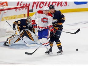 Artturi Lehkonen #62 of the Montreal Canadiens looks to tip an incoming shot in front of Henri Jokiharju #10 of the Buffalo Sabres and goaltender Carter Hutton #40 during the third period at KeyBank Center on October 9, 2019 in Buffalo, New York.
