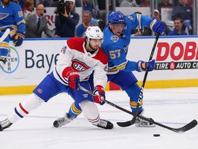 Canadiens' Phillip Danault  fights Blues' David Perron for control of the puck on Saturday, Oct. 19, 2019, in St Louis.