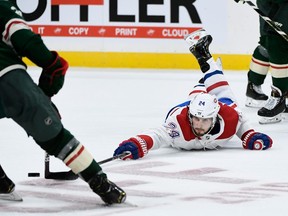 Phillip Danault of the Montreal Canadiens reaches for the puck as Carson Soucy of the Minnesota Wild takes control during the second period of the game at Xcel Energy Center on October 20, 2019 in St Paul, Minnesota. The Wild defeated the Canadiens 4-3.