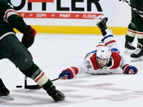 Canadiens' Phillip Danault reaches for the puck as Wild's Carson Soucy takes control at Xcel Energy Center on Sunday, Oct. 20, 2019, in St. Paul, Minn.
