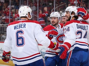 Brendan Gallagher #11 of the Montreal Canadiens is congratulated by Shea Weber #6, Tomas Tatar #90, and Phillip Danault #24 after scoring against the Arizona Coyotes Oct. 30, his 500th NHL game.