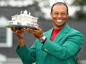 Tiger Woods celebrates with with his green jacket and trophy after winning the 2019 Masters, April 14, 2019.