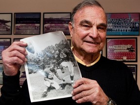 Files: Legendary football player and coach George Brancato, with a photo of himself in 1955 holding for Chicago Cardinals Pat Summerall, at his home in Ottawa in 2009
