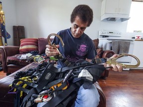 Stage technician Bienné Blémur untangles his rigging harnesses in his home.  He has been off work for three years after a co-worker called him a racial slur resulting in a battle with the union that controls the work in the city.