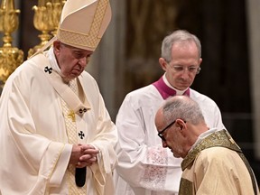 New elevated Bishop Michael Czerny (R) kneels in front of Pope Francis during the Episcopal Ordination Mass for newly elevated Bishops in St Peter's Basilica at the Vatican, on October 4 2019.