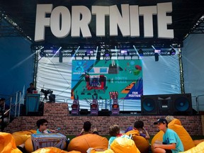 (FILES) In this file photo taken on July 27, 2019, fans sit on pillows during the 2019 Fortnite World Cup Finals - Round Two at Arthur Ashe Stadium, in New York City.