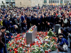 Mourners stand around a makeshift memorial of flowers and candles on October 10, 2019 at the market square in Halle and der Saale, eastern Germany, one day after the deadly anti-Semitic shooting. - Two people were shot dead in the eastern German city of Halle on October 9, 2019, with a synagogue as the prime target on Yom Kippur. The suspect, 27-year-old German Stephan Balliet, filmed the assault and live-streamed it. (Photo by Ronny HARTMANN / AFP)