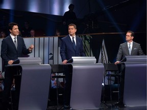 Canada's Prime Minister and Liberal leader Justin Trudeau (L), Conservative leader Andrew Scheer (C) and Bloc Quebecois leader Yves-Francois Blanchet take part in the Federal leaders French language debate at the Canadian Museum of History in Gatineau, Quebec on October 10, 2019. (Photo by Adrian Wyld / POOL / AFP)