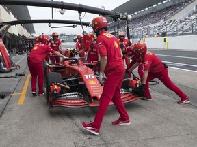 Ferrari crew members tend to Charles Leclerc's car during Friday practice for the Japanese Grand Prix.
