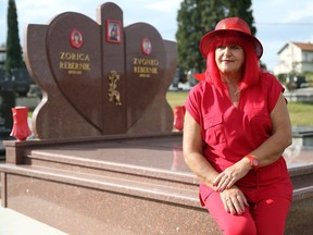 Zorica Rebernik, obsessed with the colour red, sits on her grave in the village of Breze near Tuzla, Bosnia and Herzegovina October 16, 2019. REUTERS/Dado Ruvic