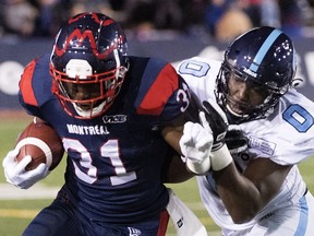 Argonauts' Tobi Antigha, tackles Alouettes' William Stanback during first half Friday night. Stanback became the first Montreal tailback to rush for 1,000 yards since Tyrell Sutton in 2015.