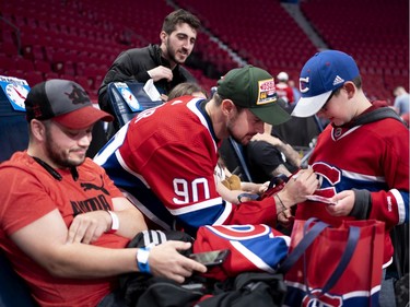 Tomas Tatar signs a jersey for Brandon Taillefer as his father, Justin Alrie, rests after giving blood during the annual Montreal Canadiens' blood drive at the Bell Centre on Wednesday, Oct. 23, 2019.