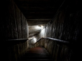 Stairs winding down a dark tunnel.