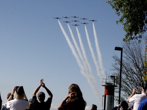 Spectators cheer as the Canadian Forces Snowbirds fly past.