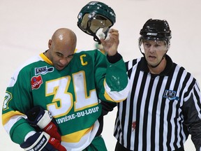 Riviere-du-Loup's Donald Brashear, left, is escorted off the ice after fighting during third period of a Ligue Nord Americaine de Hockey league game, in Trois-Rivieres in 2011.