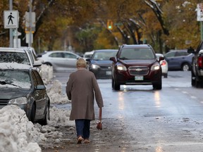 A pedestrian avoids a messy sidewalk and takes Harrow Street heading north toward Corydon Avenue in Winnipeg on Saturday.